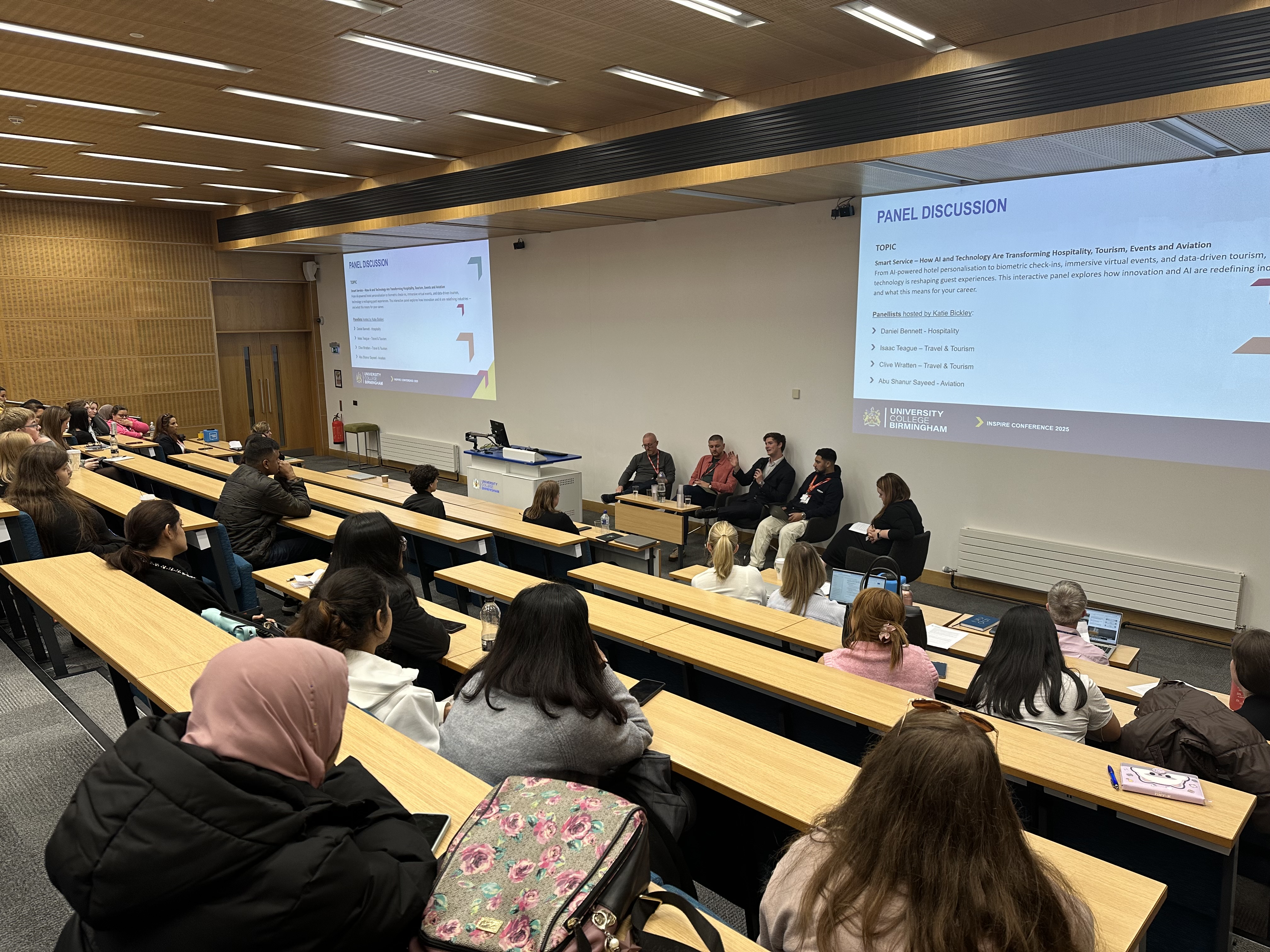 A panel of guest speakers and allumni student discussing in front of a lecture theatre