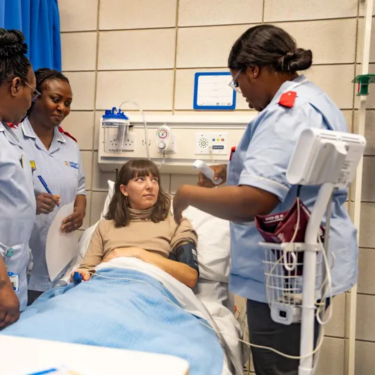 Patient being assessed by nursing students in a medical room