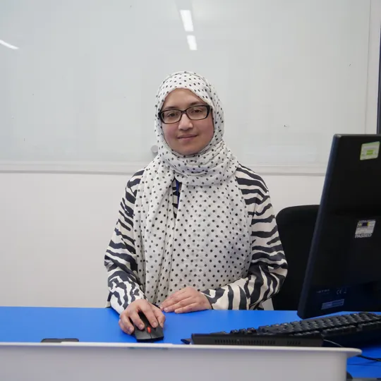 Image of a lecturer stood at a computer