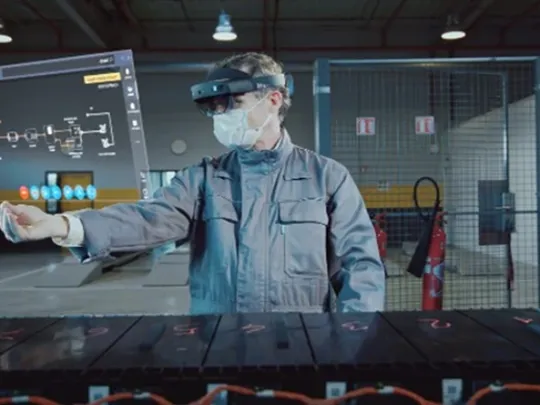 Person using AI within manufacturing holding a virtual screen with AI google on.
