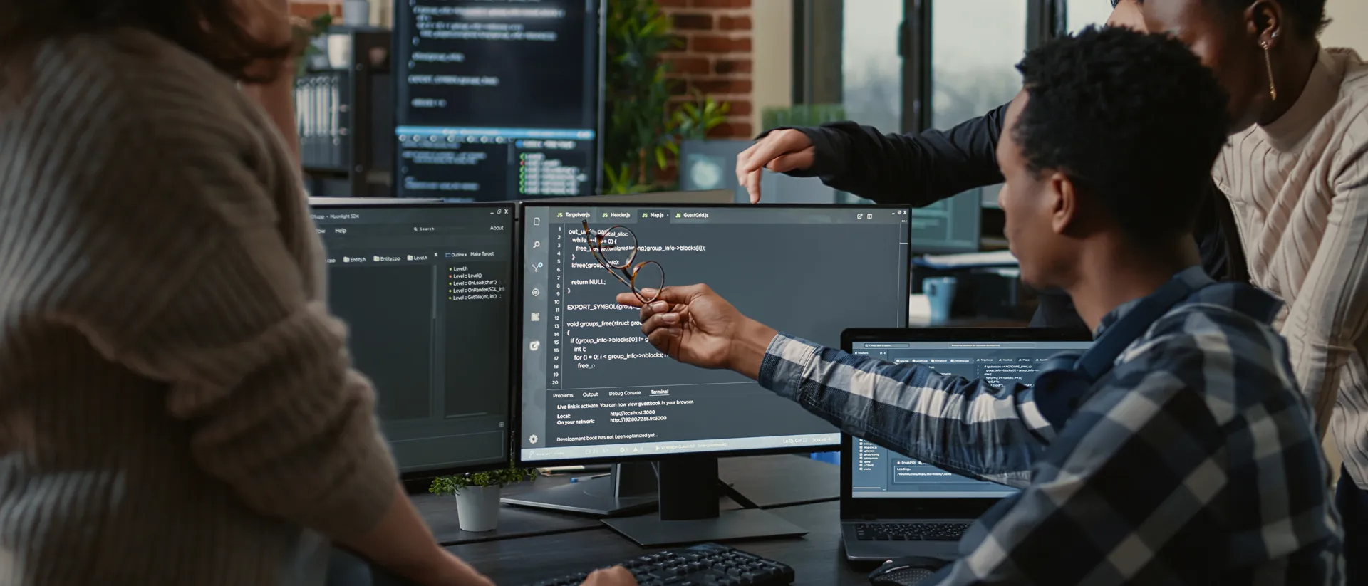 Group of young people problem solving software at a computer.