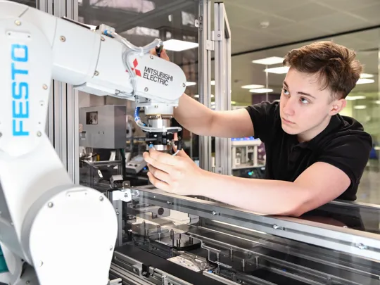 Student working with a robotic arm.