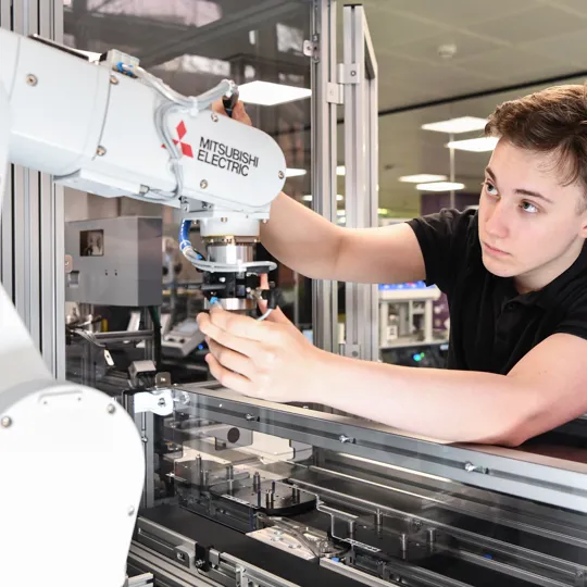 Student working with a robotic arm.