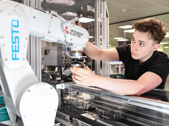 Student working with a robotic arm.