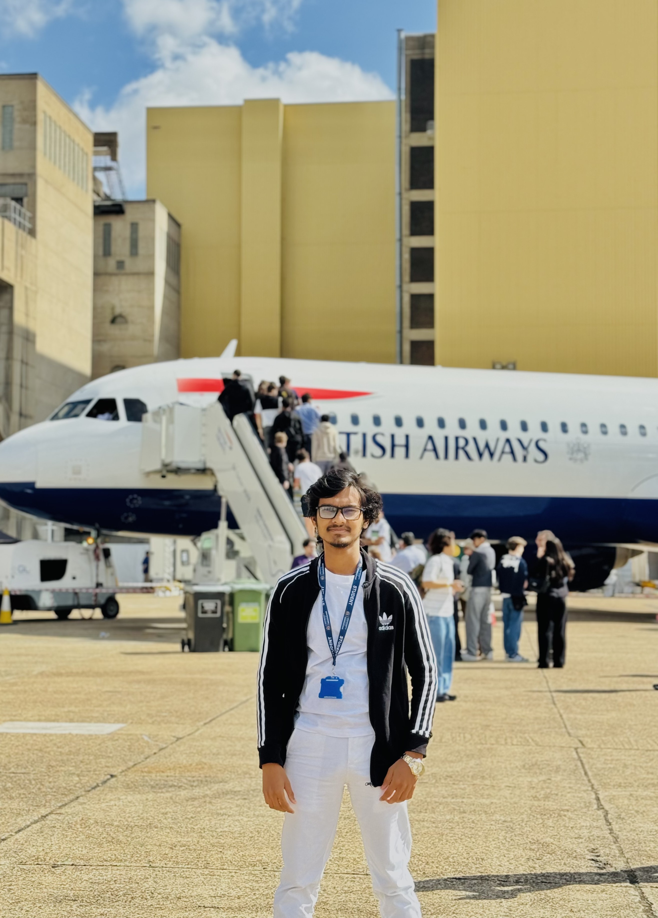 An engineering male student stood in front of a British Airways plane