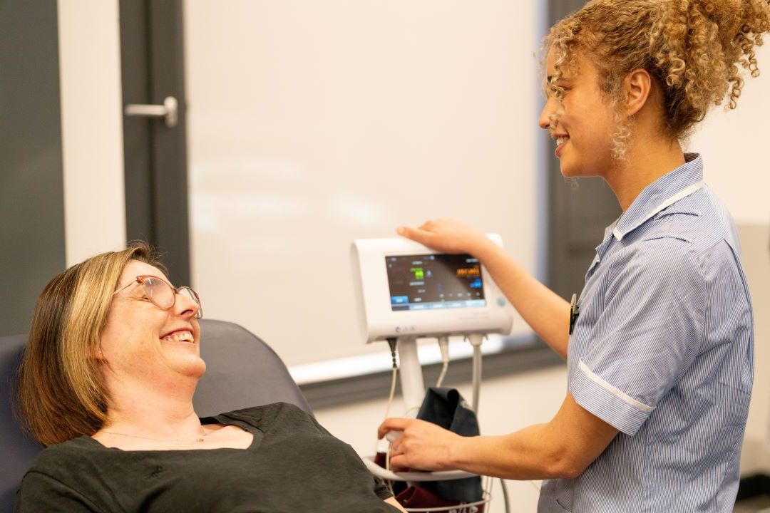 A nursing student checking vitals of a patient