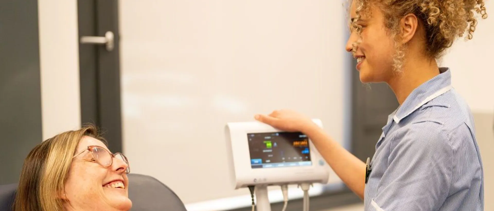 A nursing student checking vitals of a patient
