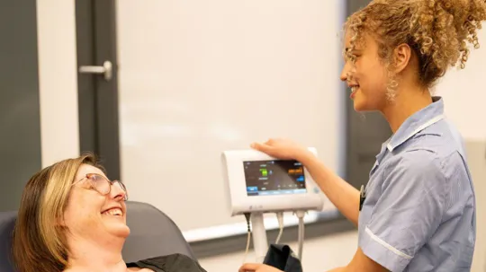 A nursing student checking vitals of a patient