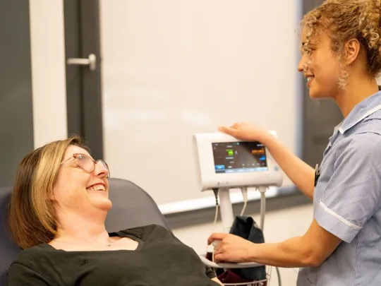 A nursing student checking vitals of a patient