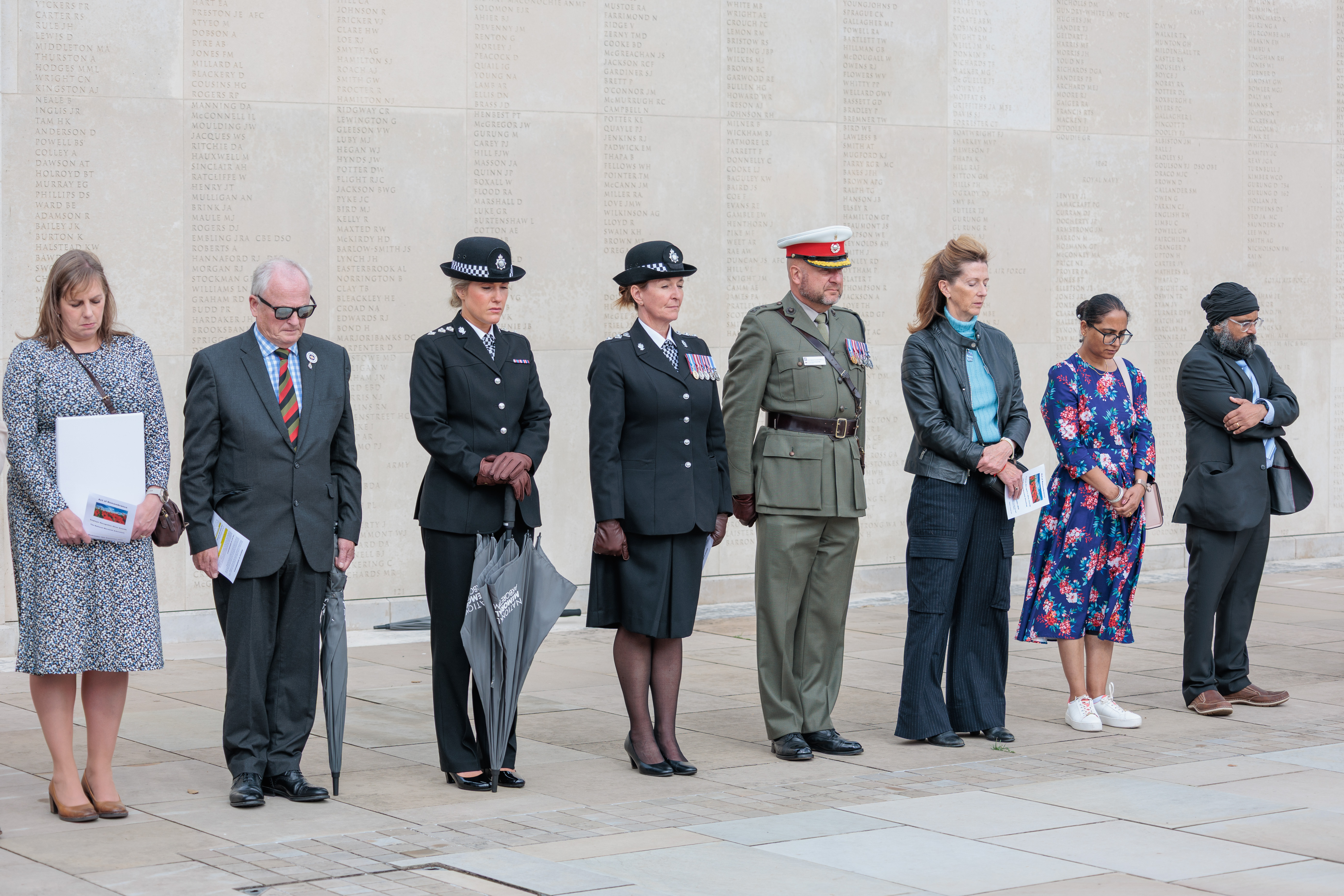 Recipients of the Defence Employer Recognition Scheme (ERS) Silver Award stand in remembrance at the National Remembrance Gardens' service