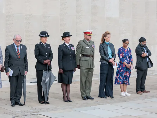 Recipients of the Defence Employer Recognition Scheme (ERS) Silver Award stand in remembrance at the National Remembrance Gardens' service