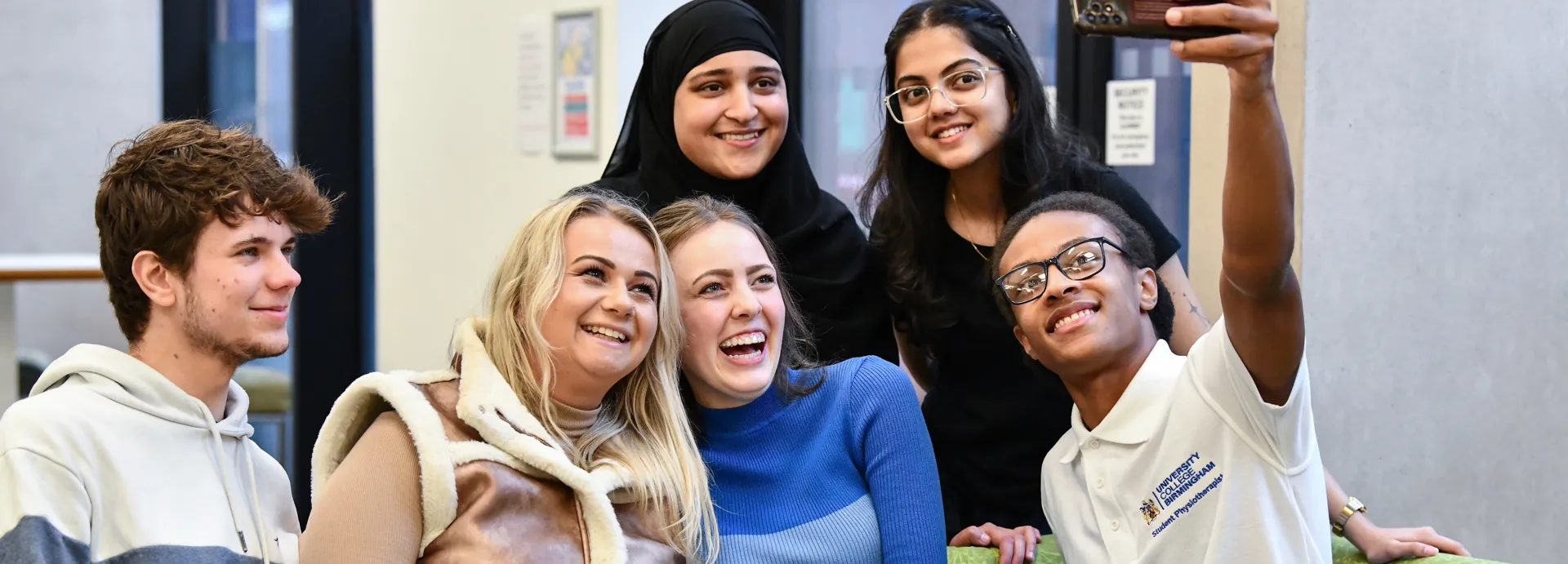 Student Ambassadors engaging in a group selfie and smiling.
