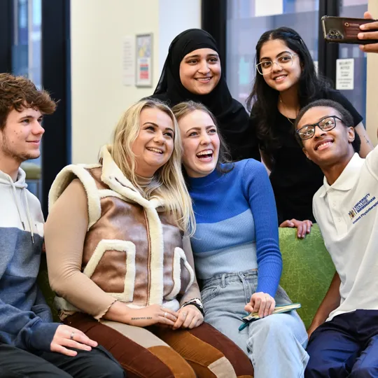 Student Ambassadors engaging in a group selfie and smiling.