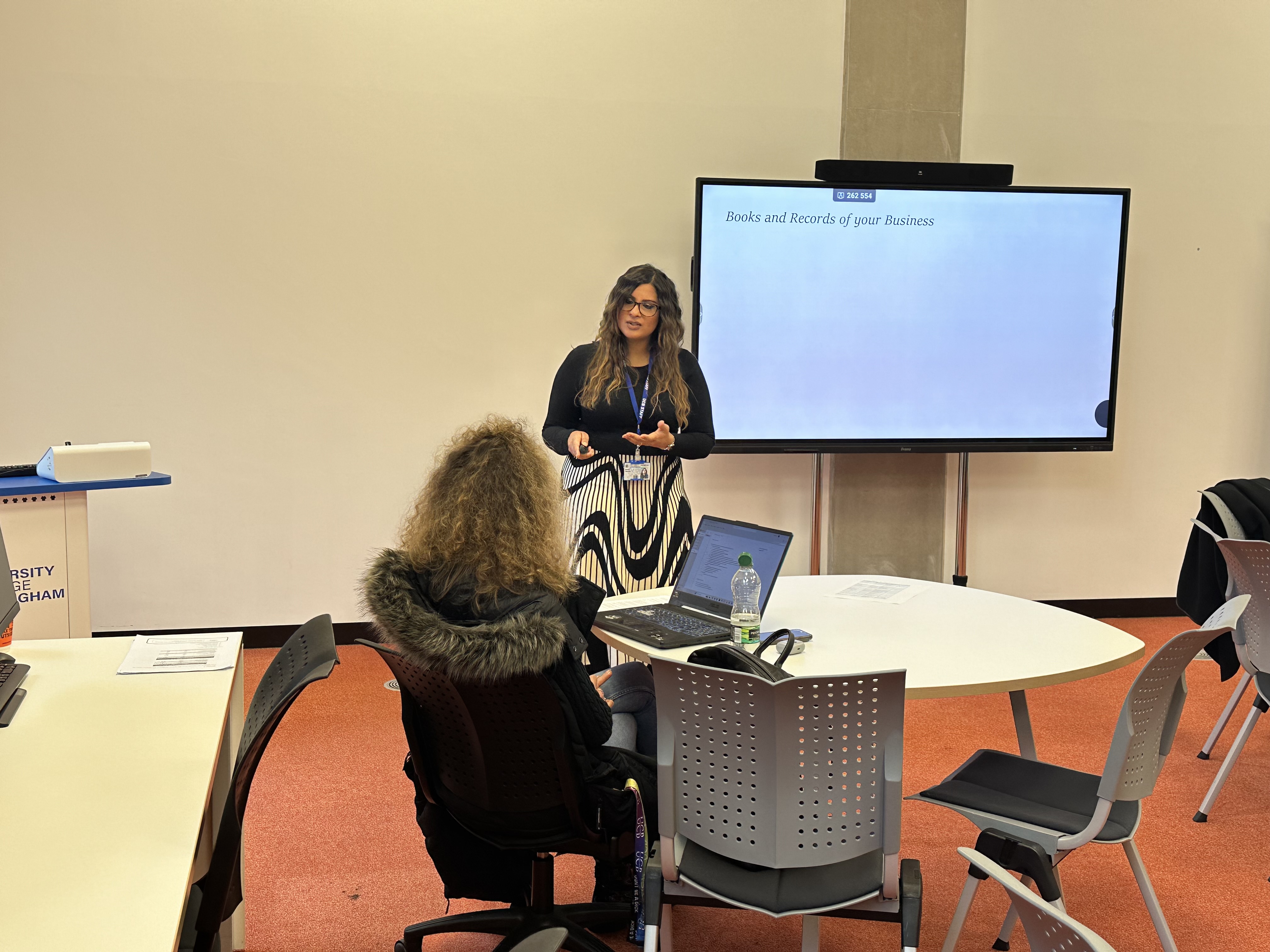 A student listening to a staff member answering a question on business banking 