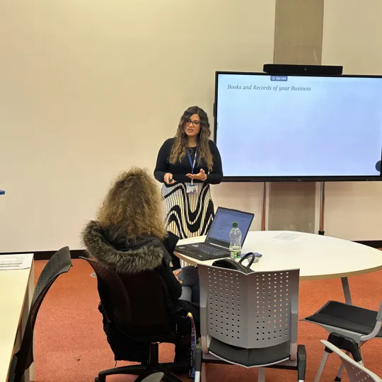 A student listening to a staff member answering a question on business banking