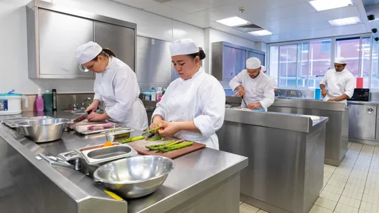 Apprentice chef cooking in kitchen